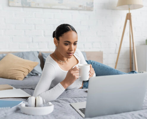 A woman relaxes into a hypnotherapy session on her computer