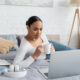 A woman relaxes into a hypnotherapy session on her computer