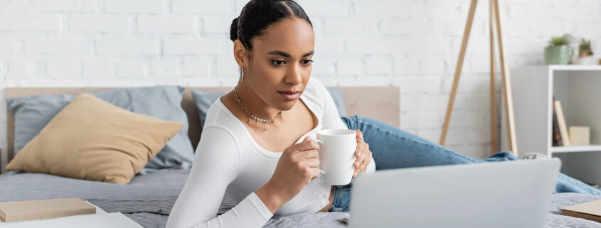 A woman relaxes into a hypnotherapy session on her computer